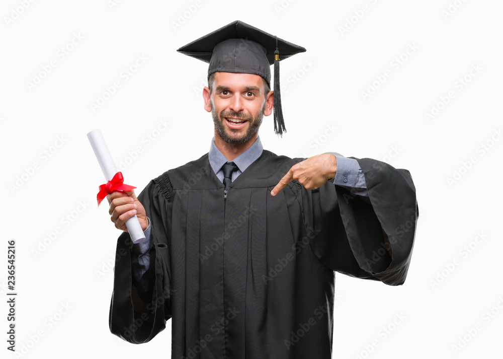 Young handsome graduated man holding degree over isolated background with surprise face pointing finger to himself Young handsome graduated man holding degree over isolated background with surprise face pointing finger to himself