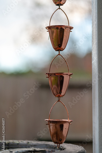 Hanging copper rain chain cups for gutter photo