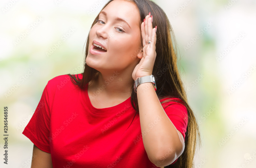 Young beautiful caucasian woman over isolated background smiling with hand over ear listening an hearing to rumor or gossip. Deafness concept.