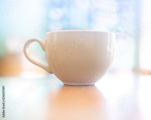 Coffee cup with sunny pastel blurred background