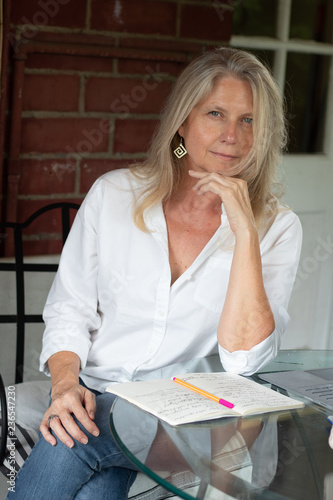 Blonde mature woman with messy hair and notebook