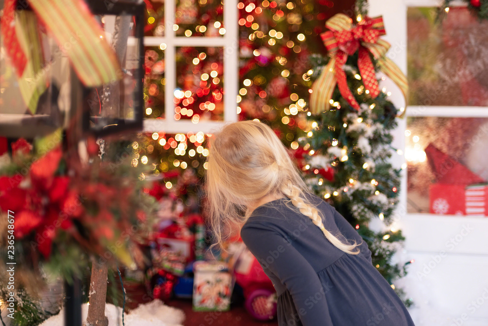 Little blonde girl looking at holiday lights and decorations Little blonde girl looking at holiday lights and decorations