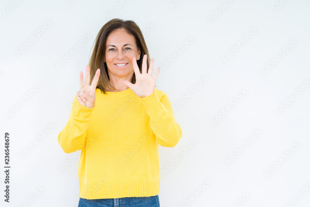 Beautiful middle age woman wearing yellow sweater over isolated background showing and pointing up with fingers number eight while smiling confident and happy. Beautiful middle age woman wearing yellow sweater over isolated background showing and pointing up with fingers number eight while smiling confident and happy.
