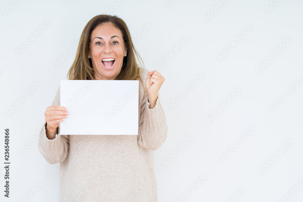 Middle age woman holding blank paper sheet over isolated background screaming proud and celebrating victory and success very excited, cheering emotion Middle age woman holding blank paper sheet over isolated background screaming proud and celebrating victory and success very excited, cheering emotion