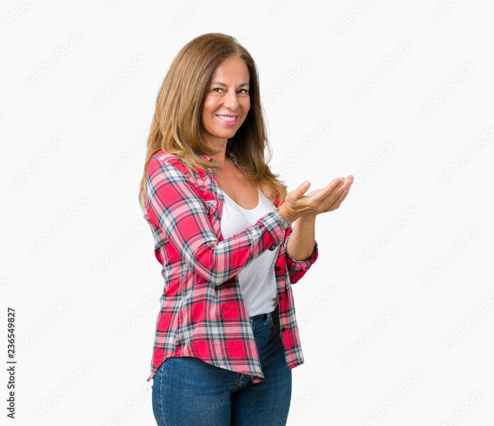 Beautiful middle age woman wearing over isolated background Pointing to the side with hand and open palm, presenting ad smiling happy and confident Beautiful middle age woman wearing over isolated background Pointing to the side with hand and open palm, presenting ad smiling happy and confident