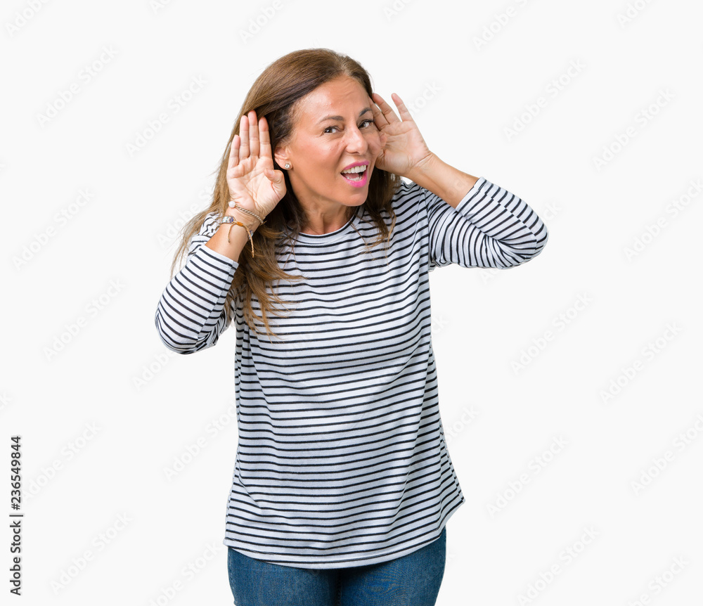 Beautiful middle age woman wearing stripes sweater over isolated background Trying to hear both hands on ear gesture, curious for gossip. Hearing problem, deaf Beautiful middle age woman wearing stripes sweater over isolated background Trying to hear both hands on ear gesture, curious for gossip. Hearing problem, deaf