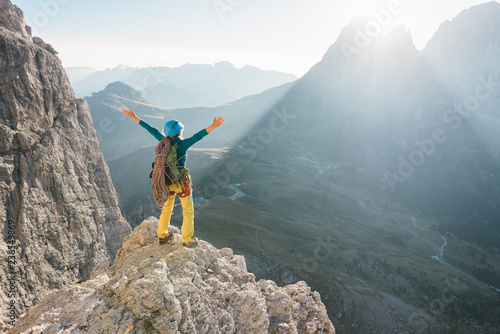 Rear view of female rock climber on top of the mountain photo
