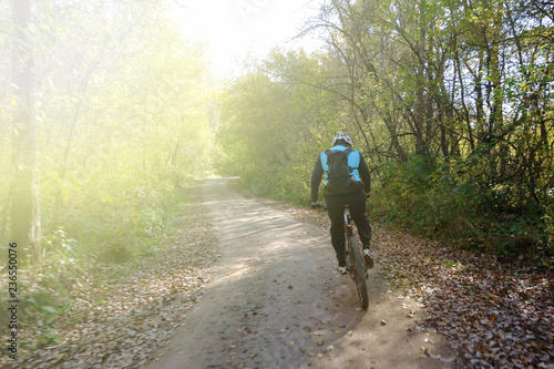 a man with a backpack riding a bike in the woods on the trail