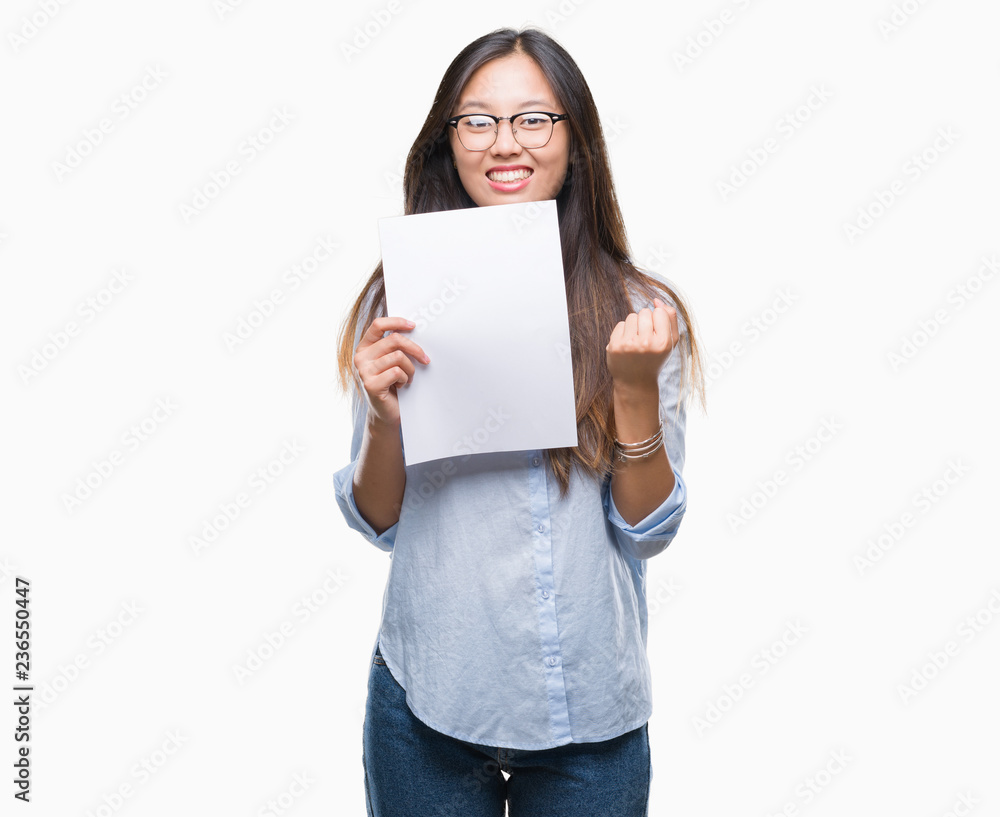Young asian woman holding blank paper over isolated background screaming proud and celebrating victory and success very excited, cheering emotion Young asian woman holding blank paper over isolated background screaming proud and celebrating victory and success very excited, cheering emotion