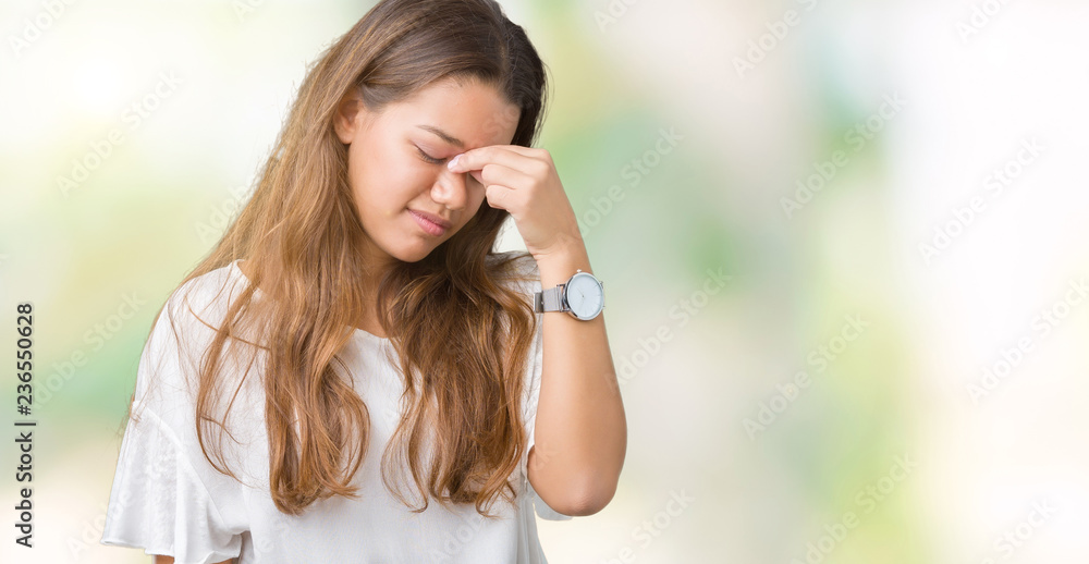 Young beautiful brunette business woman over isolated background tired rubbing nose and eyes feeling fatigue and headache. Stress and frustration concept. Young beautiful brunette business woman over isolated background tired rubbing nose and eyes feeling fatigue and headache. Stress and frustration concept.