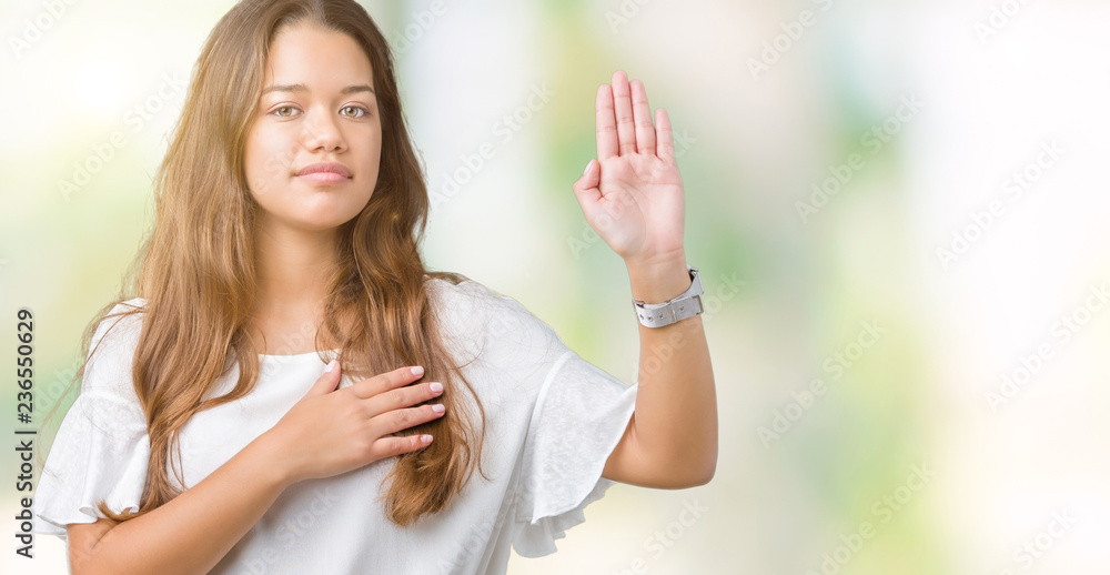 Young beautiful brunette business woman over isolated background Swearing with hand on chest and open palm, making a loyalty promise oath Young beautiful brunette business woman over isolated background Swearing with hand on chest and open palm, making a loyalty promise oath