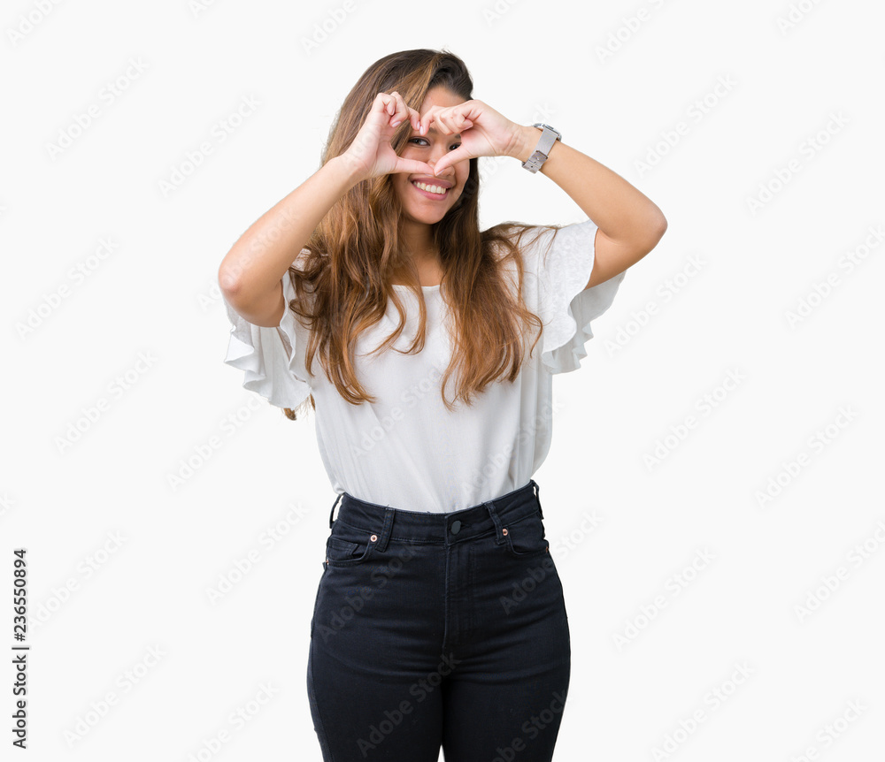 Young beautiful brunette business woman over isolated background Doing heart shape with hand and fingers smiling looking through sign Young beautiful brunette business woman over isolated background Doing heart shape with hand and fingers smiling looking through sign