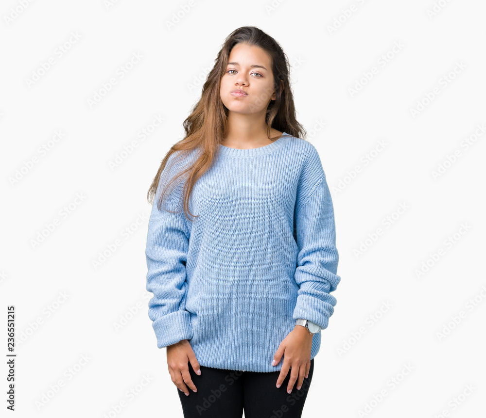 Young beautiful brunette woman wearing blue winter sweater over isolated background puffing cheeks with funny face. Mouth inflated with air, crazy expression. Young beautiful brunette woman wearing blue winter sweater over isolated background puffing cheeks with funny face. Mouth inflated with air, crazy expression.