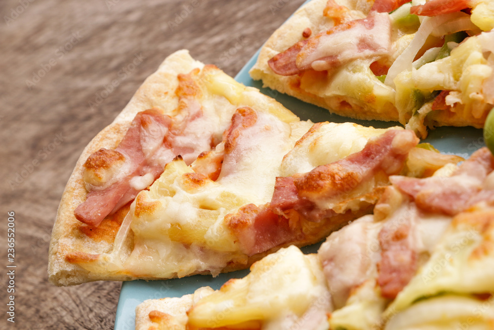Hot pizza slice on wooden table Hot pizza slice on wooden table