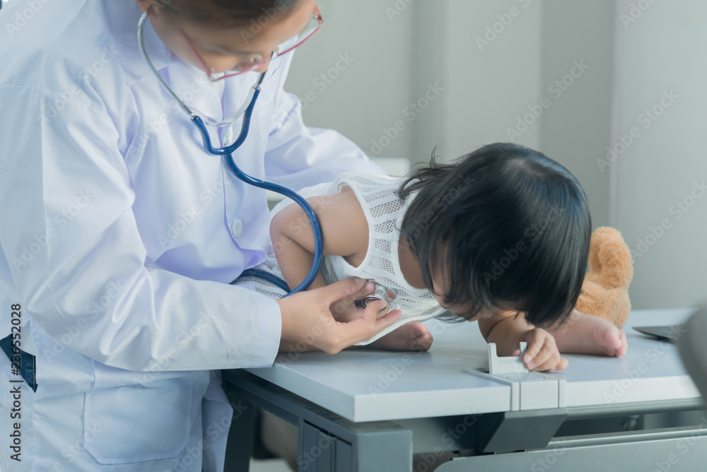 Asian doctor using a stethoscope to check his breathing and heart of a lovely girl, check the health of children,Thailand people Asian doctor using a stethoscope to check his breathing and heart of a lovely girl, check the health of children,Thailand people