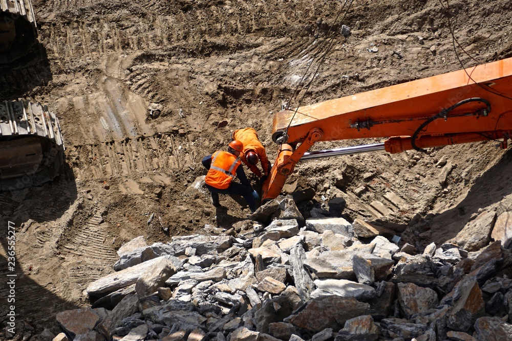 New York City, New York, USA: Workmen examining machinery used for breaking up Manhattan schist bedrock as construction begins on a new building in midtown Manhattan. New York City, New York, USA: Workmen examining machinery used for breaking up Manhattan schist bedrock as construction begins on a new building in midtown Manhattan.