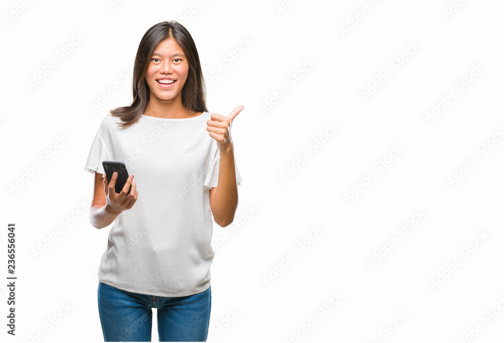 Young asian woman texting using smartphone over isolated background happy with big smile doing ok sign, thumb up with fingers, excellent sign Young asian woman texting using smartphone over isolated background happy with big smile doing ok sign, thumb up with fingers, excellent sign