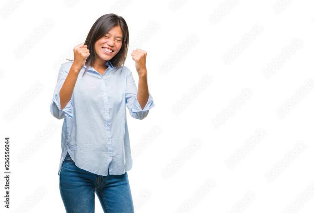 Young asian business woman over isolated background very happy and excited doing winner gesture with arms raised, smiling and screaming for success. Celebration concept.