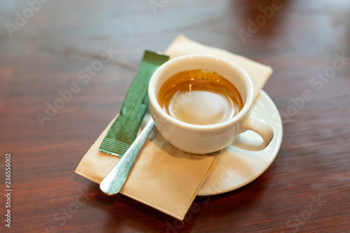 Hot coffee on wood background, sugar packets.