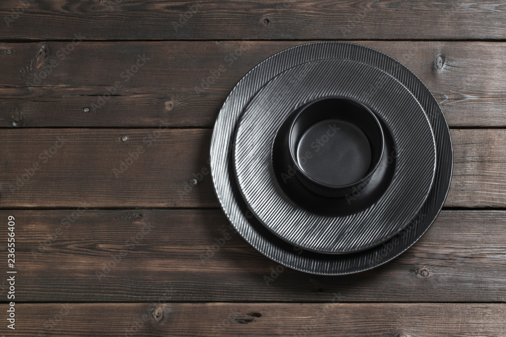 Fototapeta premium black plates on wooden background