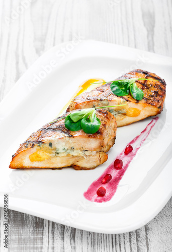 Grilled stuffed chicken breast with cheese and eggs on plate on wooden background close up. Hot Meat Dishes. Top view