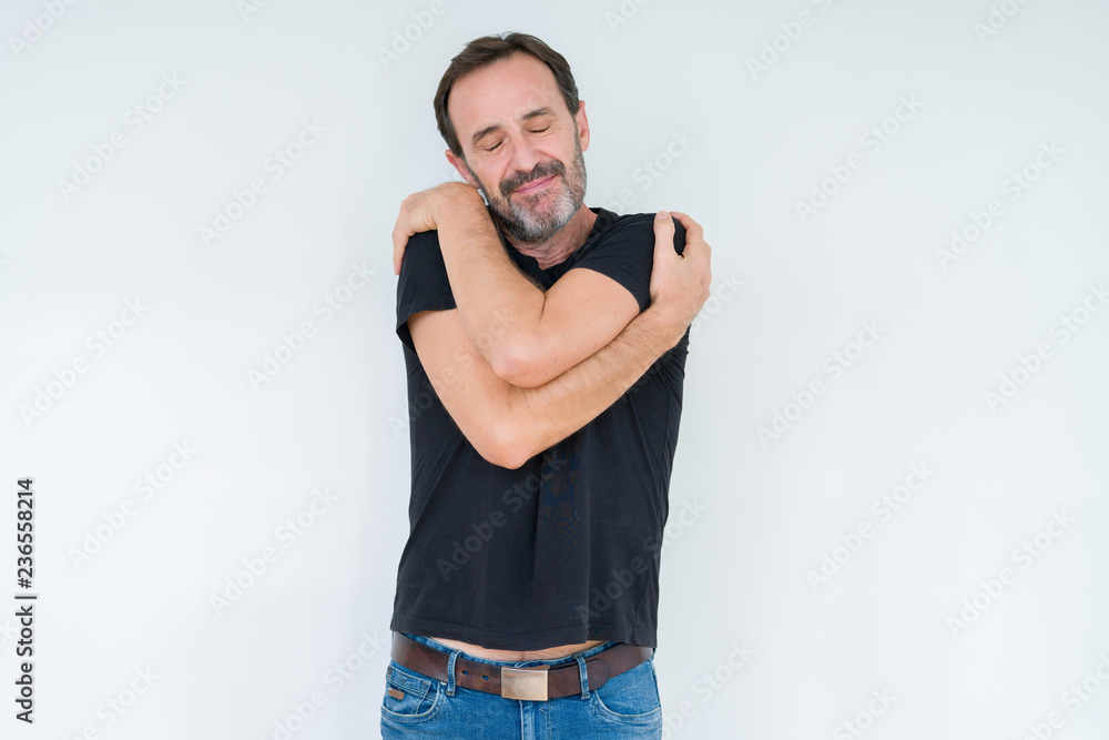 Senior man over isolated background Hugging oneself happy and positive, smiling confident. Self love and self care Senior man over isolated background Hugging oneself happy and positive, smiling confident. Self love and self care