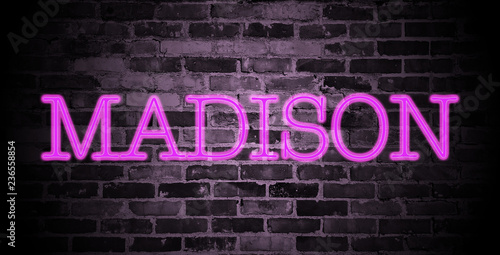 first name Madison in pink neon on brick wall