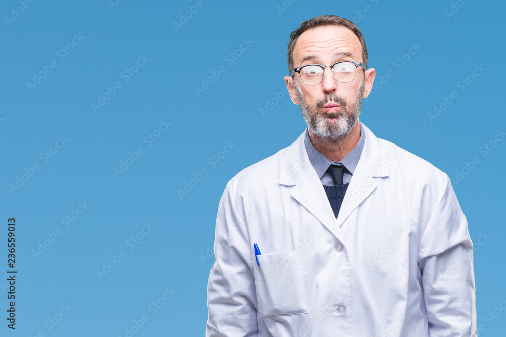 Middle age senior hoary professional man wearing white coat over isolated background puffing cheeks with funny face. Mouth inflated with air, crazy expression. Middle age senior hoary professional man wearing white coat over isolated background puffing cheeks with funny face. Mouth inflated with air, crazy expression.
