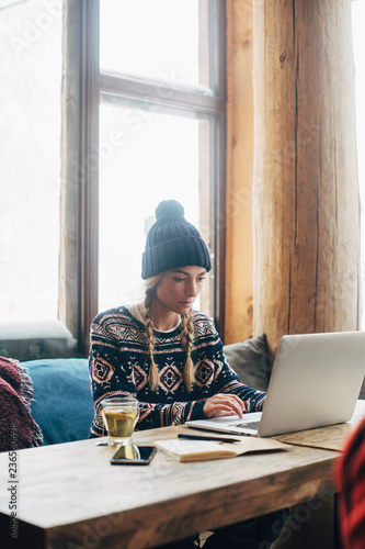 Woman Working on Her Laptop at Log Cabin photo