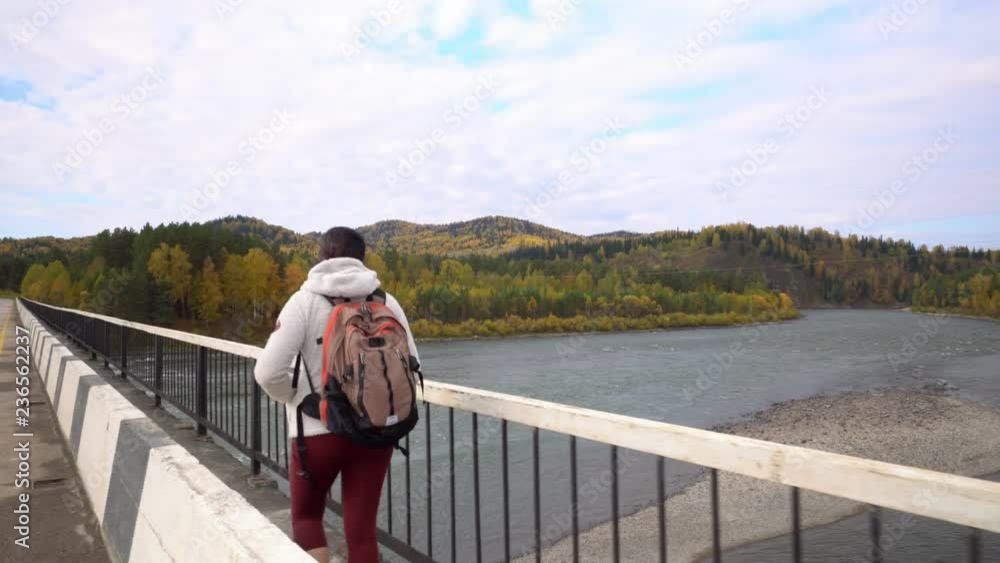 Altai. The woman the traveler costs on the bank of the mountain river. Two videos in one. Altai. The woman the traveler costs on the bank of the mountain river. Two videos in one.