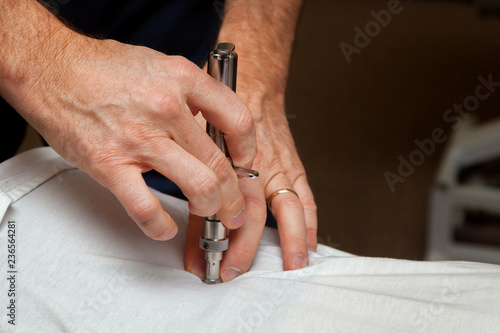 Εκτύπωση καμβά Hands of a Chiropractor Using an Integrator to Adjust the Spine of a Patient