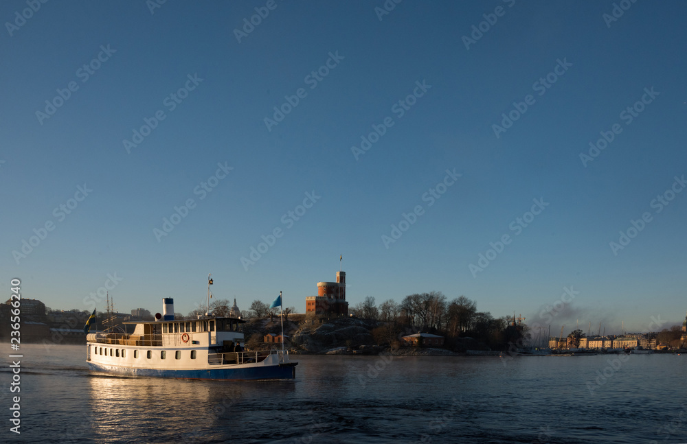 A sunny morning in stockholm harbour, ships and boats in the frosty mist and winter light