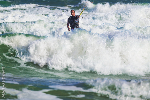 Young athletic man riding kite surf on a sea