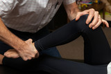 Hands of a Chiropractor Adjusting the Leg of a Young Girl at her Knee and Ankle
