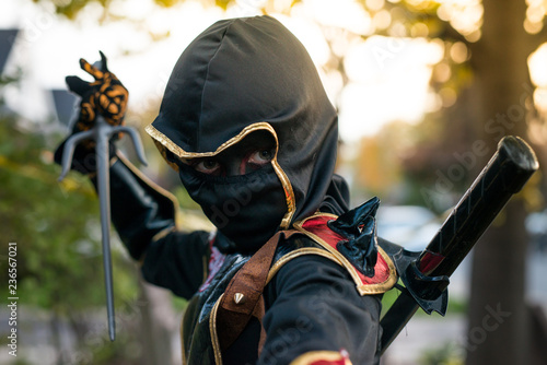 Boy dressed as a ninja makes a threatening face
