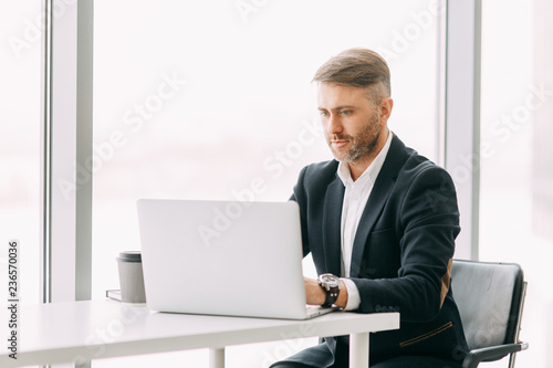 An employee at the laptop, the business aspects. Bright and stylish office interior and cut out the background.