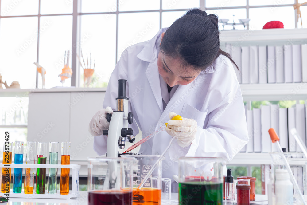 asian scientists dripping chemicals for the microscope in the laboratory to perform some research. asian scientists dripping chemicals for the microscope in the laboratory to perform some research.