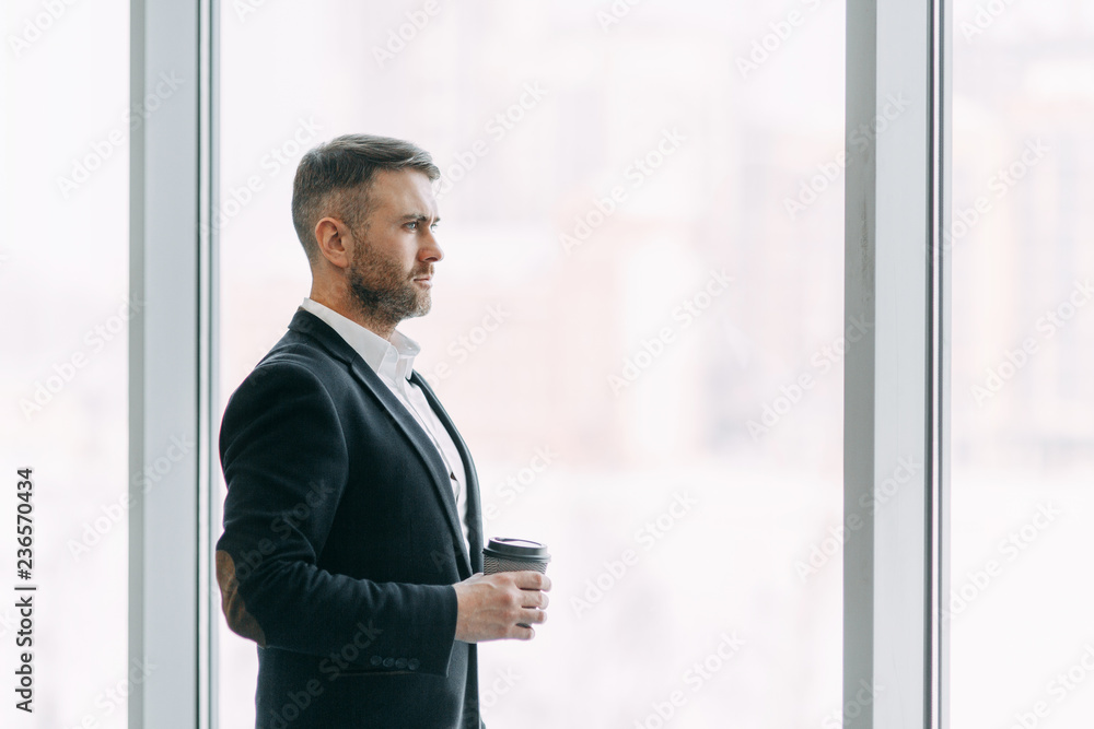 Coffee break after work in the office. Bright interior with a businessman. Coffee break after work in the office. Bright interior with a businessman.