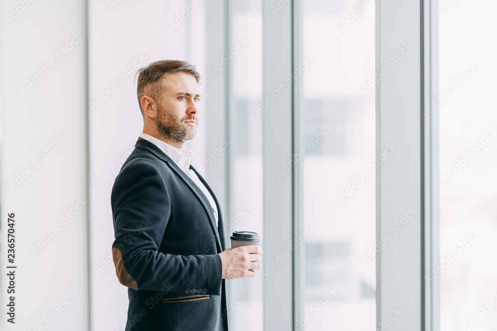 Coffee break after work in the office. Bright interior with a businessman. Coffee break after work in the office. Bright interior with a businessman.