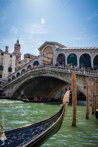 The Rialto bridge on Grand canal is a famous landmark of Venice ,Italy, with blue sky ,and gondola boat over water