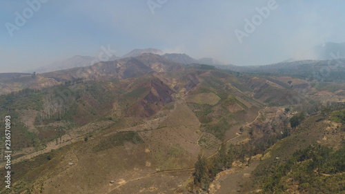 Mountain hilly landscape in rural areas with agricultural land in Java Indonesia. aerial view slopes mountains covered with vegetation. mountain landscape © Alex Traveler