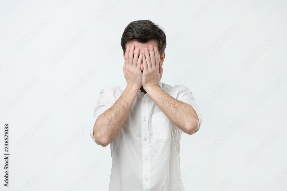 Man in white shirt covered his face with his hands. Social conflict dconcept Man in white shirt covered his face with his hands. Social conflict dconcept