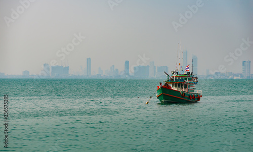 Colorful Traditional Thai Fishing Boat with the city of Pattaya in the Background.