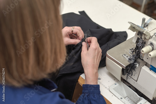 A woman sews on an electric sewing machine.