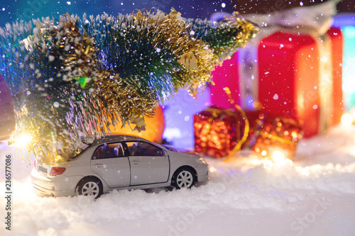 Toy car carries gifts in the Christmas and new year's eve. Concept of holiday shopping and discounts