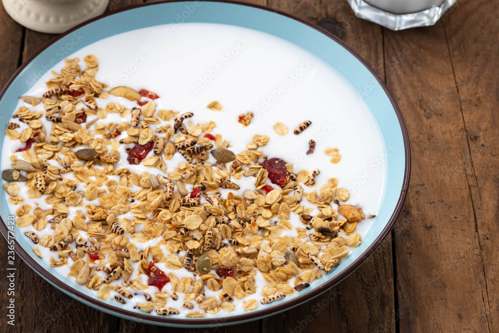 Granola, oatmeal with milk, honey and strawberry on blue wooden table.
Granola, oatmeal with milk, honey and strawberry on blue wooden table.