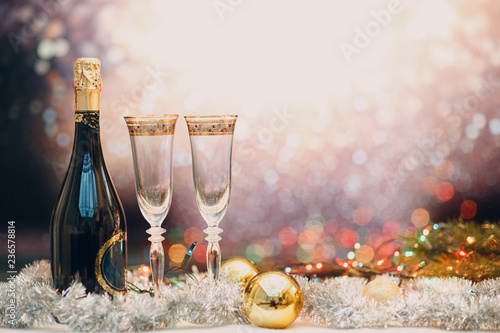 New years eve celebration background with champagne and a pair of glasses with christmas decoration. Party and celebration concept. Copy space.