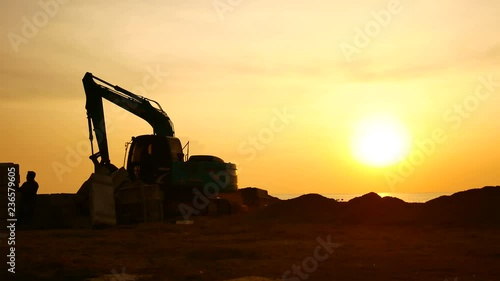 Wallpaper Mural Construction Video At construction site The silhouette excavator is digging ground and lifting a large mortar, with engineering and construction workers to help with colorful sunset . Torontodigital.ca