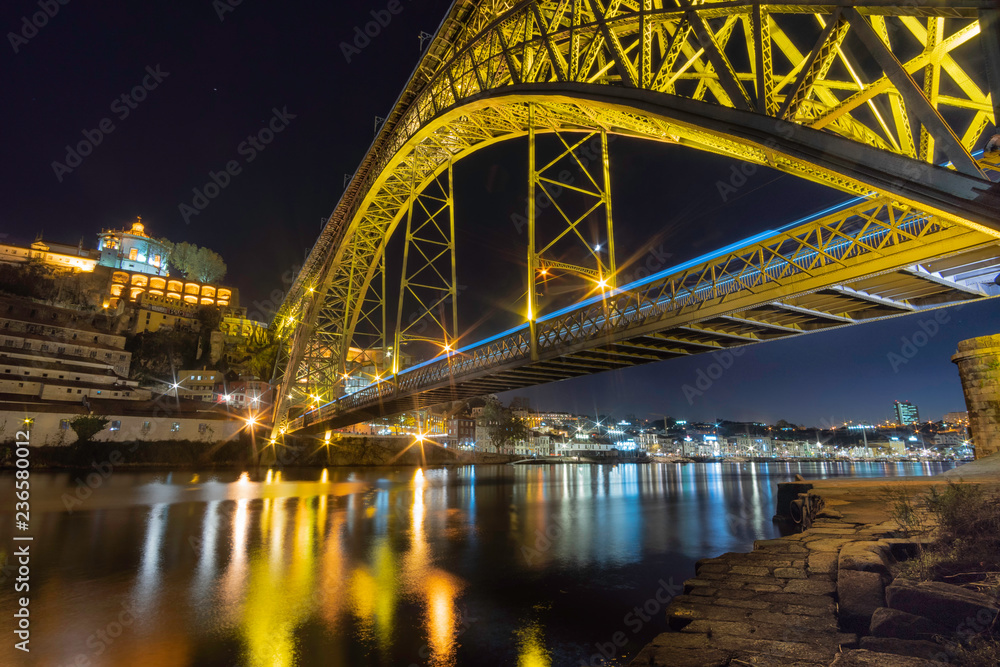 dom luise bridge at night with a blu car fast driving porto portugal