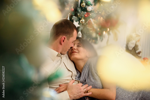 Pregnant mother and her husband at home with christmas decorations